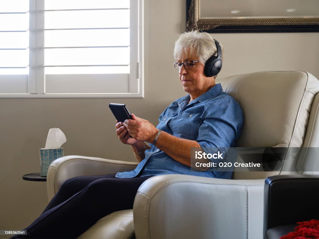 Senior woman relaxing in a lift chair while using a tablet