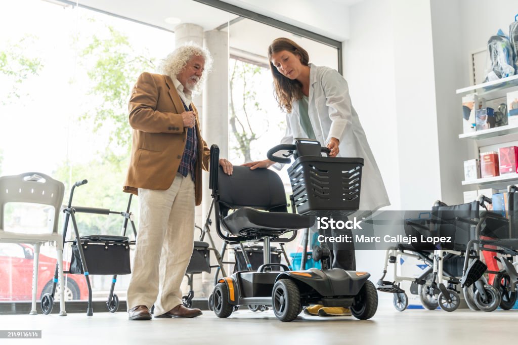Team member helping a customer try a mobility scooter in store